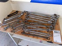 Photo showing the assortment of wrenches arranged on a table, displaying open and box ends.