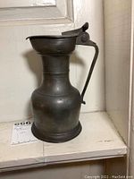 Full side view of the pewter pitcher showing its shape and handle