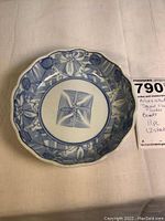 Single ceramic center bowl with blue and white scalloped floral pattern and square flower in the center.