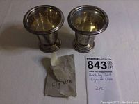 Pair of sterling silver cigarette urns from a frontal angle showing exterior condition and design.