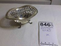 Photo showing the entire sterling silver nut bowl from a side angle with pierced edge, beaded rim, and three feet.