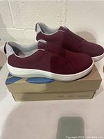 Side angled view of burgundy Clarks Arla SageCloud ladies shoe on original cardboard box