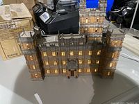 Front view of light-up Downton Abbey manor figure showing detailed windows and lighting.