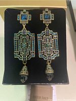 Photo showing front view of the pair of Heidi Daus geometric statement earrings with colorful rhinestones and dangling bead, displayed in black foam inside original box.