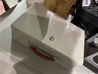 Closed view of the insulated security chest showing the key lock and brown handle.