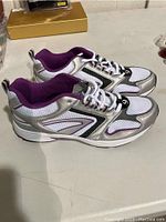 Pair of Ladies Athletic Works running shoes, white and silver with purple accents, size 9, top and side view