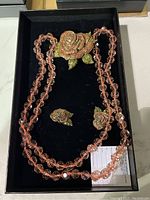 Full set showing necklace, rose brooch, and two clip-on earrings in black box