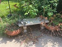 Photo of concrete bench with terracotta planters and dry vegetation