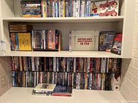 Wide view of three shelves packed with DVDs and CDs.
