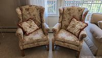 Front view of both floral wingback armchairs side by side