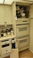 Cabinet and drawers next to oven showing kitchen appliances and utensils storage