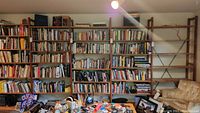 Fully assembled wall of four connected shelving modules loaded with books and items