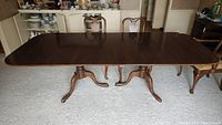 Full view of the rectangular walnut table surface and matching chairs in the background.