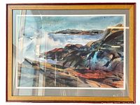 Framed watercolor seascape artwork showing crashing waves and rocky shoreline with visible birds in sky.