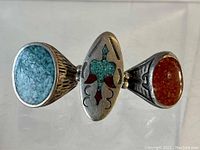 View of all three Native American sterling silver rings displayed together, showing turquoise and coral stones and detailing.