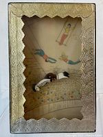 Front view of the Shackman vintage trapeze motion toy showing the trapeze artist mid-air with the audience illustration in background, featuring the ornate gold cardboard frame.