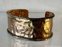 Front angled view of bracelet showing hammered 14K gold vermeil center with sterling silver rim edges.