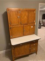 Front view of Hoosier cabinet showing upper cabinets, white laminate countertop, lower cabinet and drawers