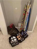 Photo of picnic case, kite, umbrellas, and carry bag with sand toys arranged against wall