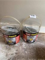 Two clear plastic buckets containing collated Senco Duraspin self feeding screws, labeled #8 x 2 1/2 inch