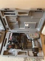Open molded plastic hard case containing the Senco Airfree 25 battery operated brad nailer, charger, and battery pack.