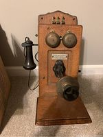 Front view of oak case telephone showing brass bells, transmitter and shelf