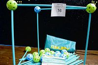 Blue rods and blue and green plastic connector balls arranged on a wooden surface with Obuby bag and instruction manual