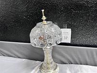 Side view of the vintage Art Deco crystal table lamp showing the textured crystal glass shade and silver-tone etched metal base.