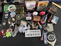 Full view of lot including vintage doll, patches, ashtray, books, and keychains