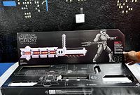 Box of Star Wars The Black Series Force FX Riot Control Baton. The box shows the baton design with red lights and schematic diagram of the baton structure with black and white details.