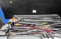 Large spread of 18 golf clubs shown together varying in size and type with metal shafts and some grips visible