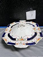 Top and angled views of the octagonal covered porcelain serving bowl with floral and gold decoration