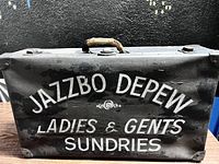 Close-up of front of roadie case with white painted text and worn handle