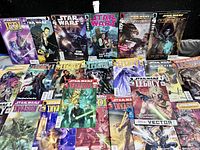 Photo showing a collection of Star Wars comic books including Jedi, Legacy, and other series arranged side by side on a flat surface.