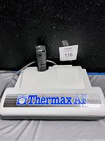 Photo of white Thermax AF vacuum cleaner floor attachment with cord and hose connector against black background.