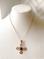 Full view of the necklace on a display bust, showing the entire chain and cross pendant with black onyx.