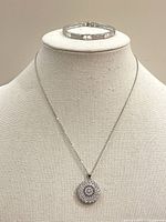 Photo of jewelry set with necklace and hinged bangle displayed on a mannequin bust