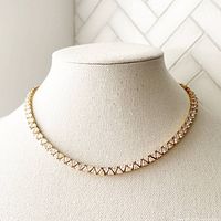 Front view of the 27 inch gold plated sterling silver trillion cut white faux diamond tennis necklace on display bust.