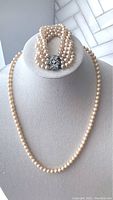 Full view of the faux pearl necklace and 4-strand bracelet displayed on a bust stand, showing the clasp detail and pearl strands.