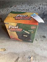 Box front and side view showing Flexi Hose brand, 100 feet length, key features, and packaging condition.