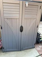 Front view of closed cabinet showing double doors and central handle