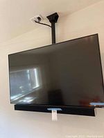 Front view of the 50 inch Vizio TV mounted from ceiling with soundbar attached below.