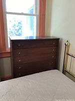 Full front view of wood veneer highboy showing all five drawers and circular metal pulls