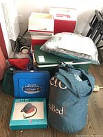 Overview of all items showing the coolers, air bed storage bag, raft in plastic, director's chairs and assorted bags including cooler bags.