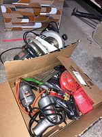 Photo showing box with two 7.25 inch SkilSaw circular saws and drill items inside.