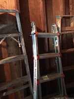 Photo showing Little Giant multiposition aluminum ladder leaning against a wall with a 6-foot wooden step ladder to the left.