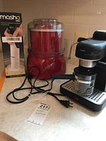 Photo showing Salton Masha potato masher in box, red ice cream maker, and Krups espresso machine on countertop with power cords.
