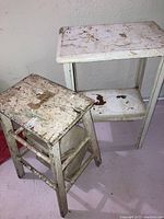 Photo of painted wood stool with drop down step and metal table showing extensive wear and paint chipping.