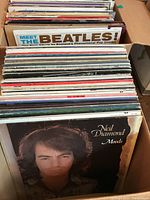 Box containing a stack of vinyl record albums showing the front cover of Neil Diamond's 'Moods' album.