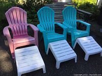 Three molded plastic Adirondack chairs (pink, two turquoise) with three white plastic footrests on driveway